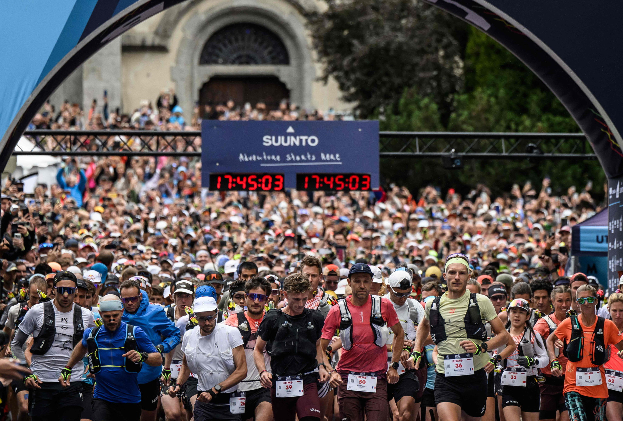 François d’Haene et des centaines de coureurs au départ de l’Ultra Trail du Mont-Blanc (UTMB) 2025 à Chamonix, sous l’arche Suunto affichant 17:45:03.