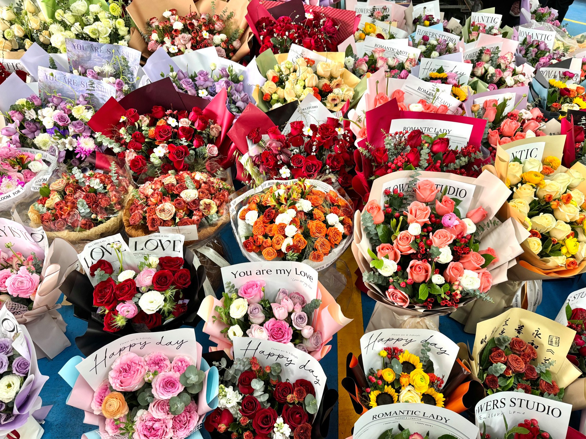 Bouquets de roses colorées en vente au marché aux fleurs de Dounan à Kunming, Chine, pour célébrer la Saint-Valentin.