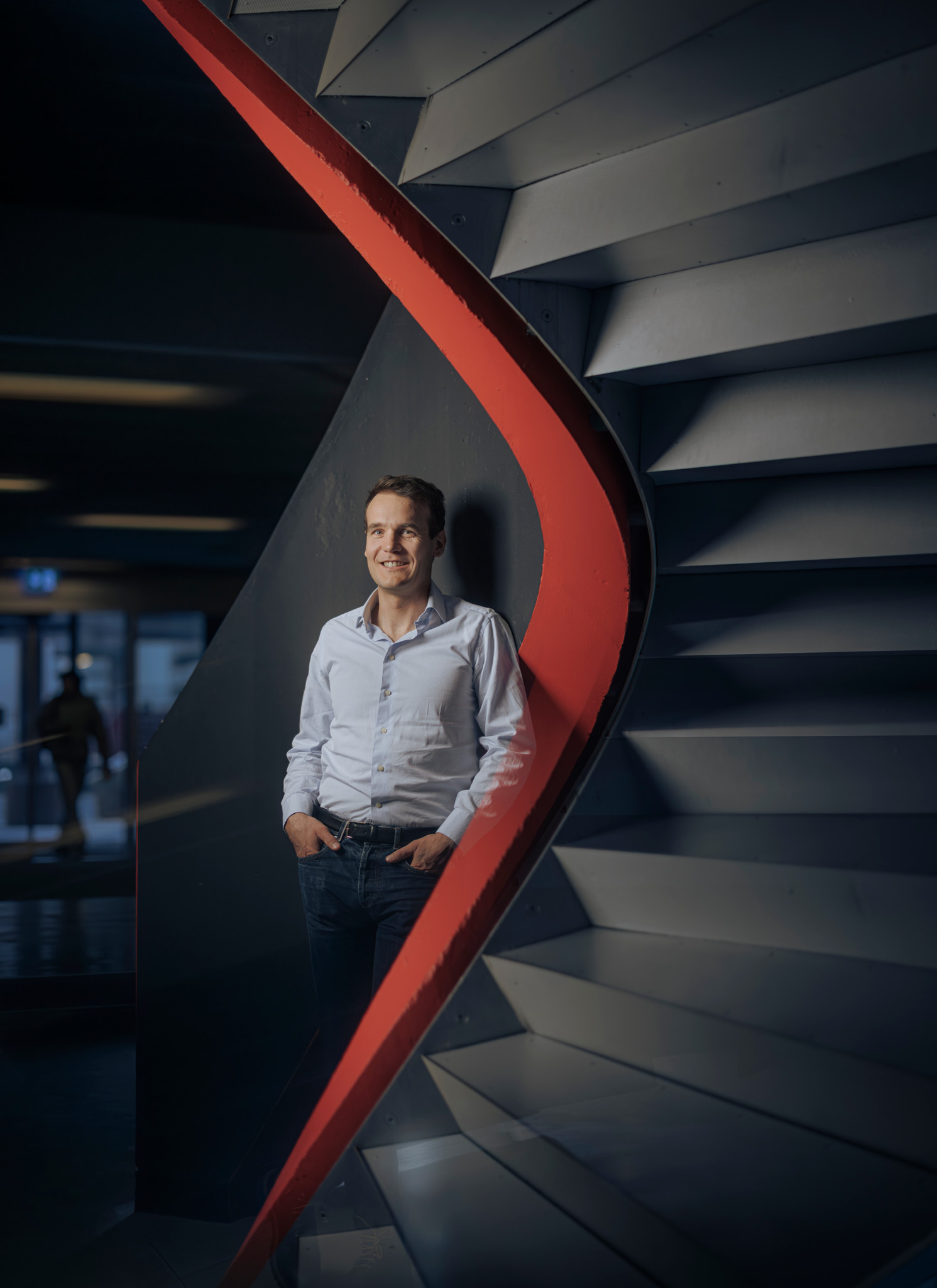 Pierre Baqué, CEO de Neural Concept, debout avec un décor moderne à l’EPFL Lausanne.