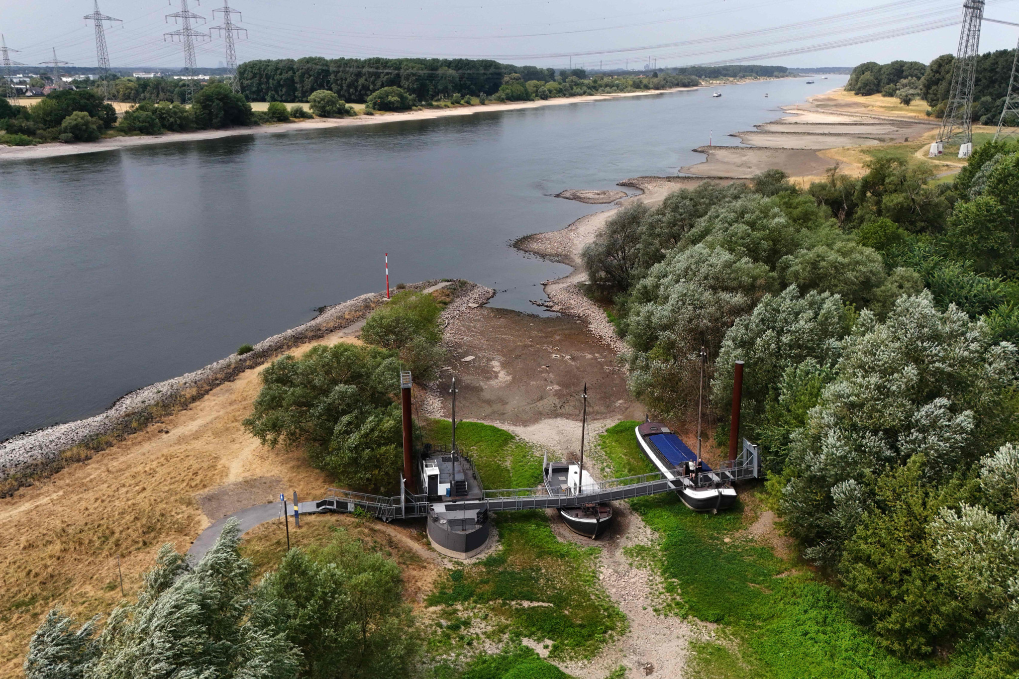 Vue aérienne de trois anciens navires échoués à sec, reliés par une passerelle-café, à la confluence de la Wupper et du Rhin près de Leverkusen, Allemagne.