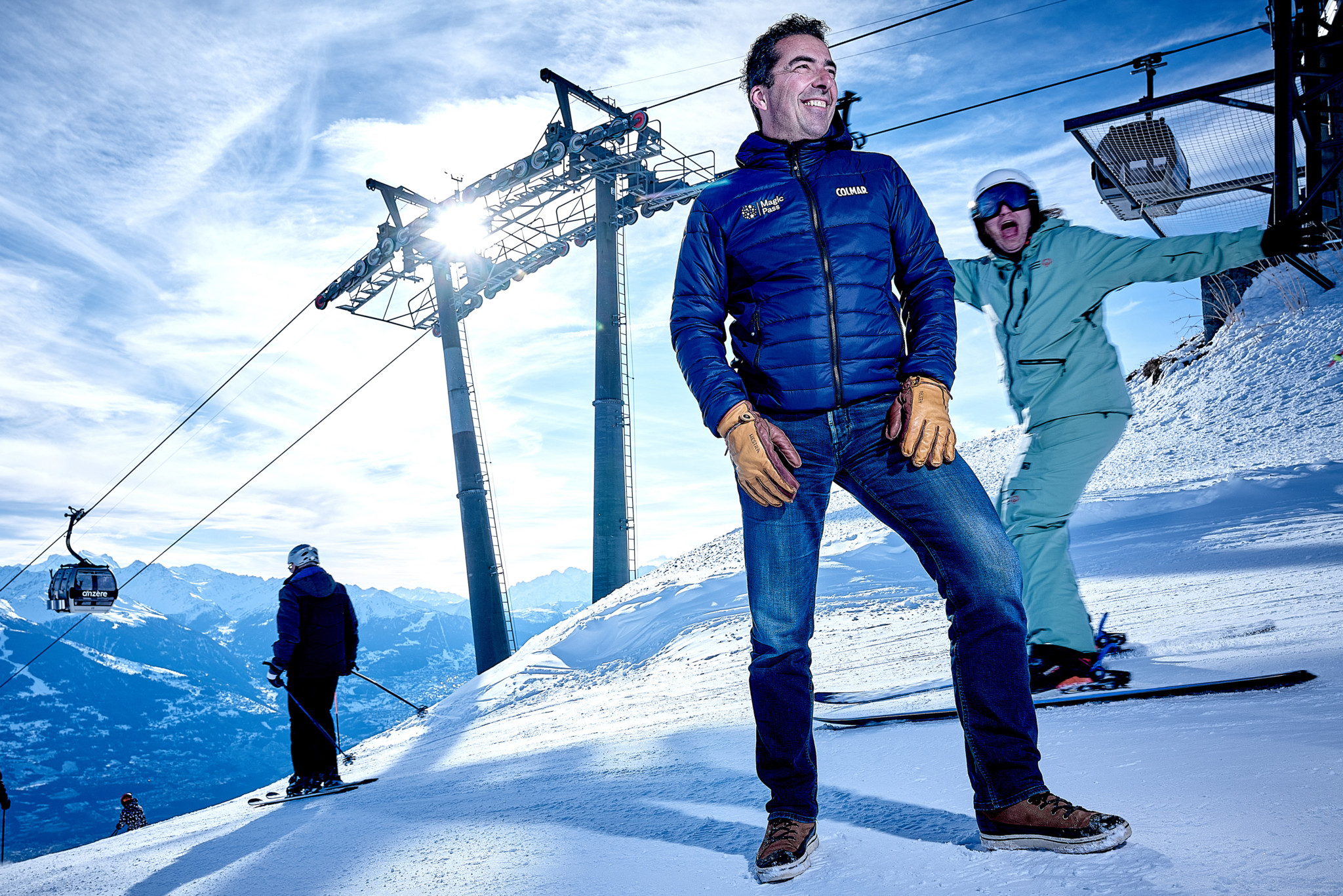 Sebastien Travelletti sur le domaine skiable d’Anzère, fondateur du Magic Pass, pose sur la neige avec les remontées mécaniques en arrière-plan.