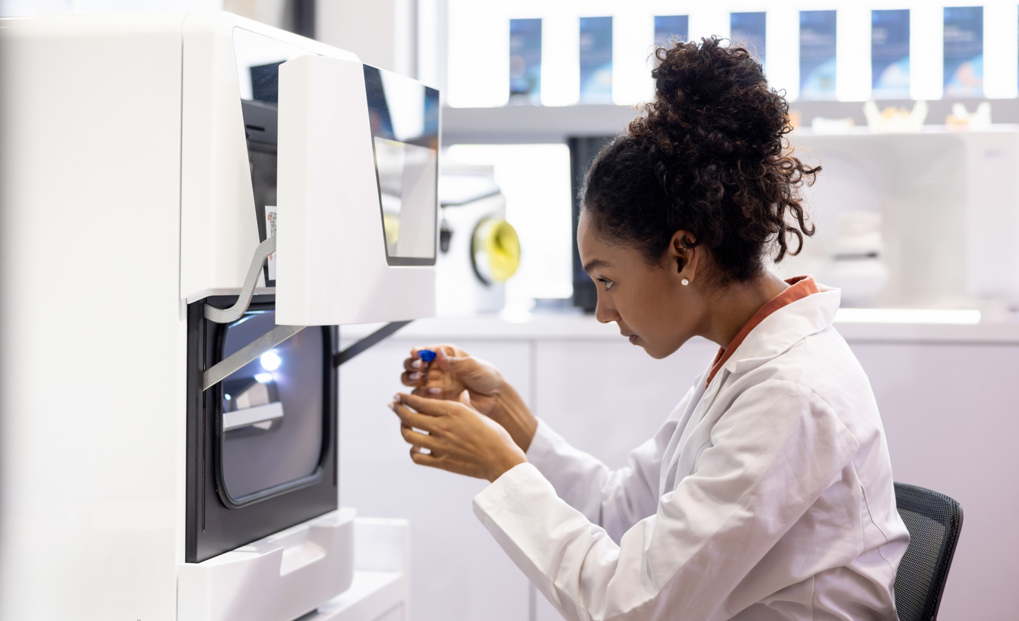 Une ingénieure en santé utilisant une imprimante 3D pour créer des modèles biologiques dans un laboratoire médical moderne.