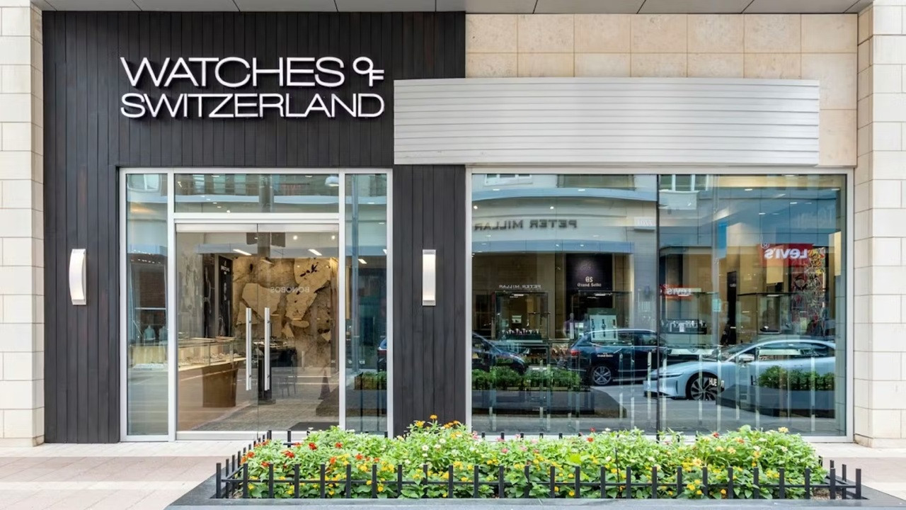 Façade élégante de la boutique Watches of Switzerland avec grandes vitrines et enseigne noire et blanche