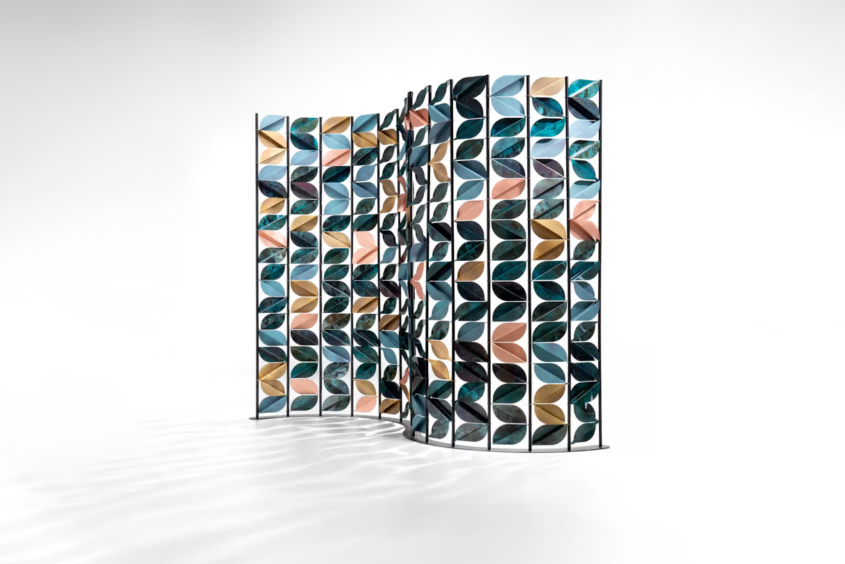 Paravent design aux motifs de feuilles colorées en bleu, rose et doré, disposé en forme de vague sur fond blanc.