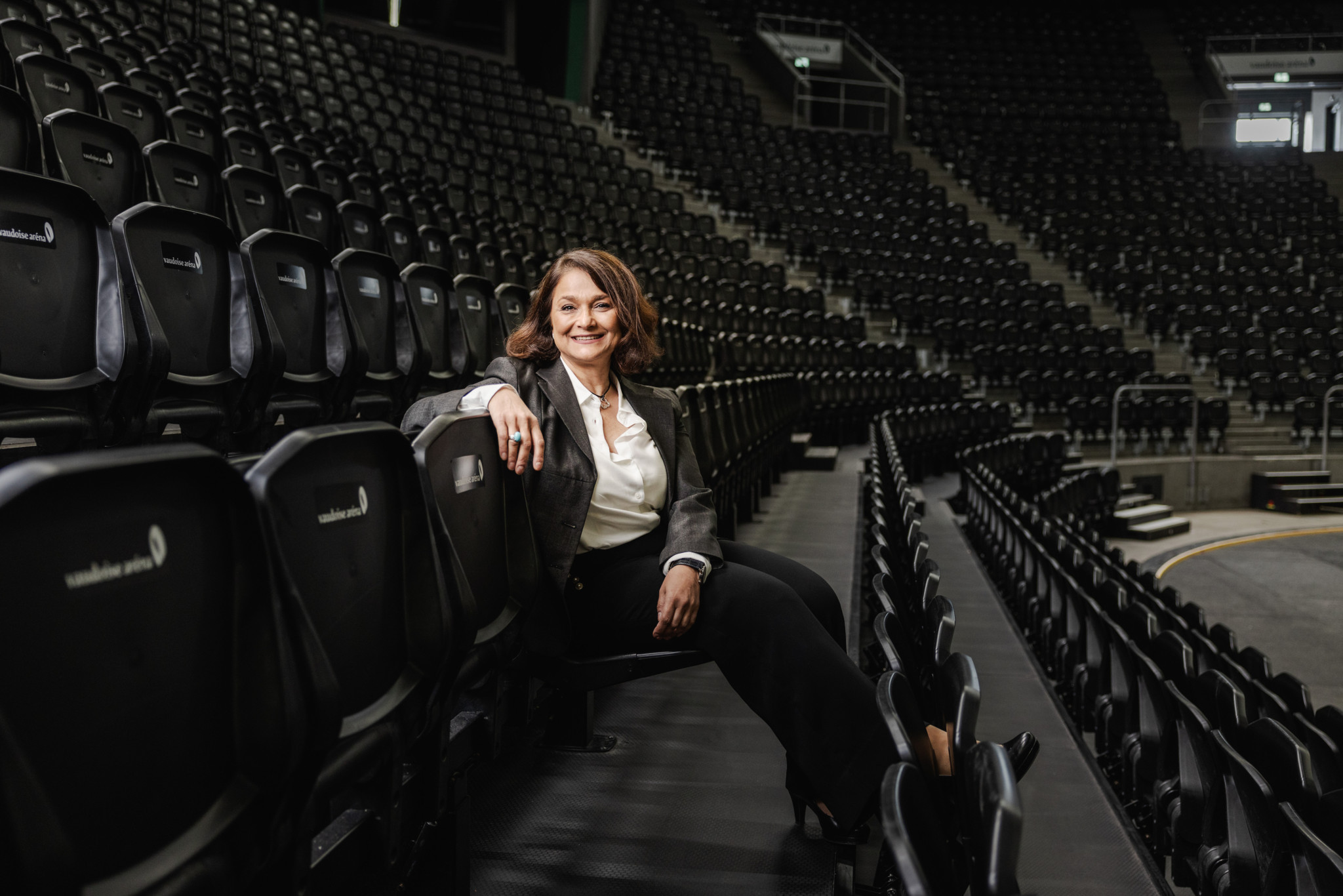 Samira Marquis, directrice générale de la Vaudoise Arena, assise dans les gradins vides de la salle de spectacle à Lausanne.