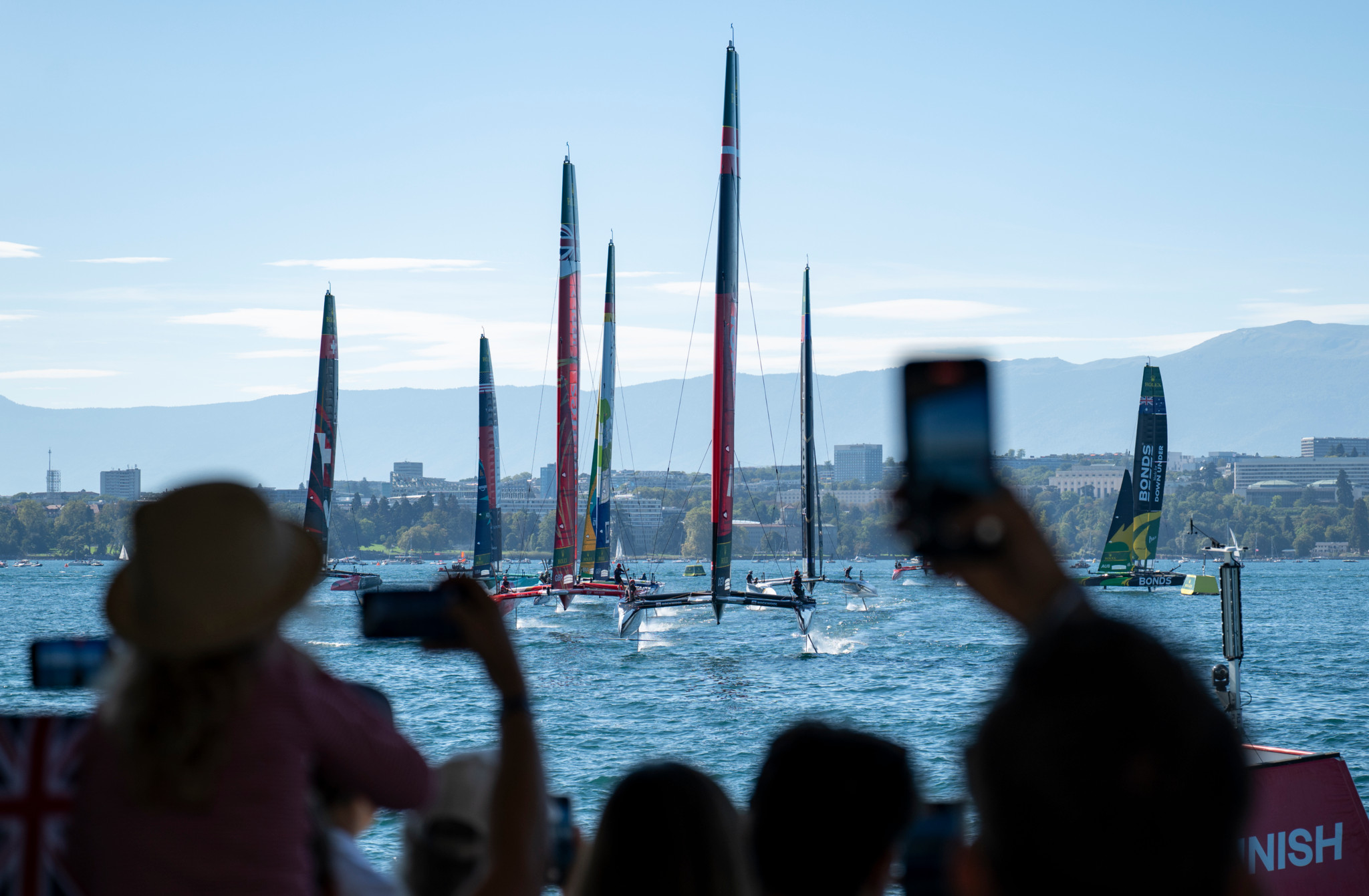 Spectateurs photographiant la flotte de voiliers du Rolex Switzerland Sail Grand Prix sur le lac Léman à Genève, le 20 septembre 2025.